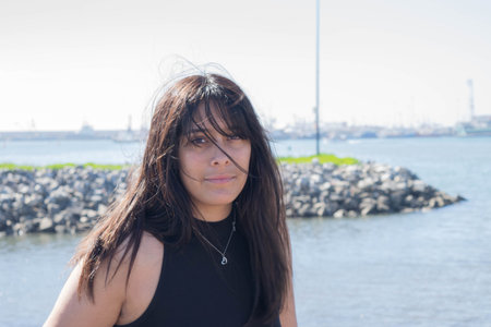 beautiful mexican girl smiling in front of the seaの写真素材