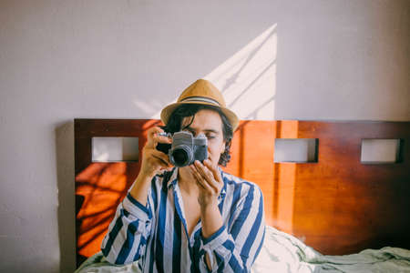 Latin woman with hipster appearance using old cameraの写真素材