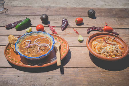 Mexican food, plate of birria and pozole with sauce and Mexican chili peppers, tomato and avocadoの写真素材