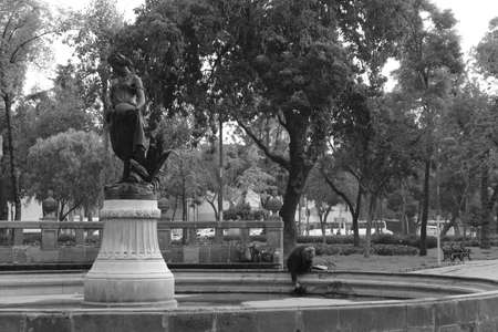 MEXICO CITY, MEXICO - September / 21 / 2018 old mexican woman washing her clothes in fountain dedicated to goddess PersÃ©foneのeditorial素材