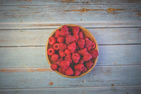 top view of fresh raspberries in rustic bowl