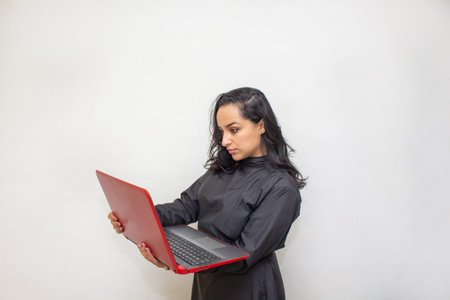 female doctor in surgical suit and n95 face mask working with laptop