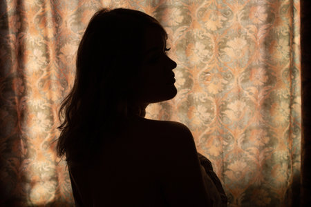 sexy backlit portrait in gold tone of woman with sensual lips. Silhouetteの写真素材