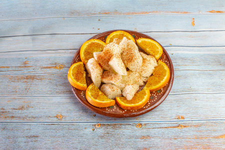jicama with orange slices with chili powder on a Mexican clay plate. healthy snack
