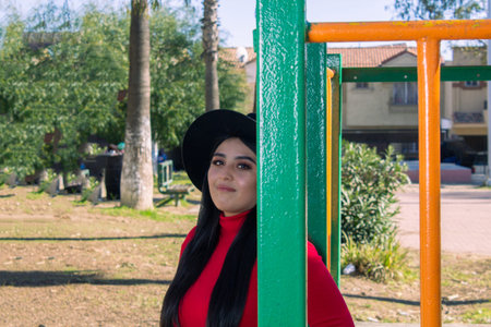 beautiful Mexican woman with fedora hat looking at the camera in the park.young hispanicの写真素材