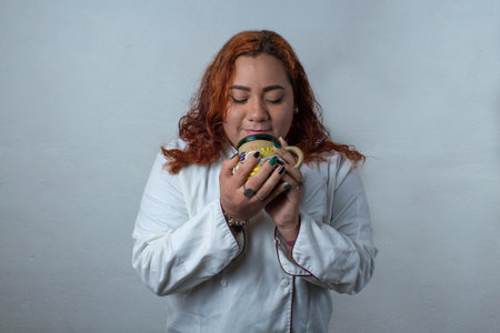 Happy Mexican woman enjoying cup of coffee. latin cookの写真素材