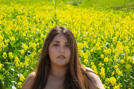 beautiful Hispanic woman sitting in a field of yellow flowers. chubby model