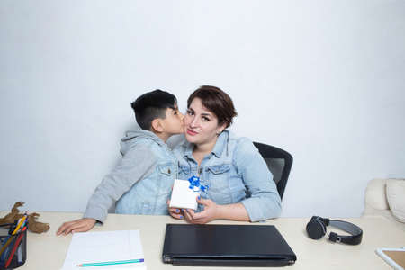 mom and son celebrating mothers day with gift on video call for pandemic and new normalの写真素材