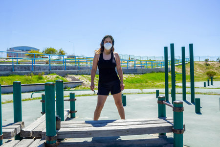 Latin fitness woman inspiring standing in the middle of calisthenics training park