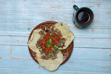 real carnitas tacos with salsa and vegetables next to a cup of Mexican coffee. Mexican foodの写真素材