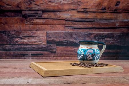 mexican coffee in colorful folk cup on old boards with coffee beans