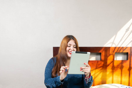 happy fat redhead model using tabletの写真素材