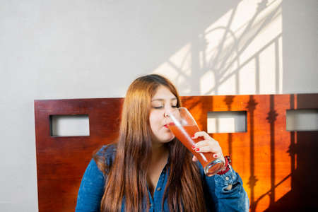 beautiful overweight woman drinking bloody mary cocktail. micheladaの写真素材