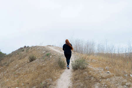 chubby woman running up hill running in sportswear. workoutの写真素材