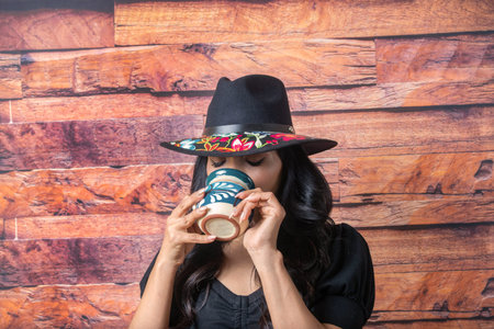 mexican woman drinking chocolate coffee from colorful cup to relax