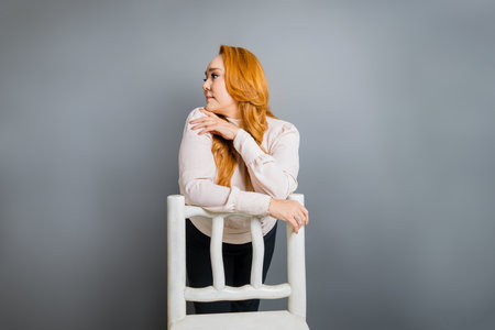 Caucasian Hispanic senior woman wearing elegant in photograph executive leaning on rustic chair looking asideの写真素材