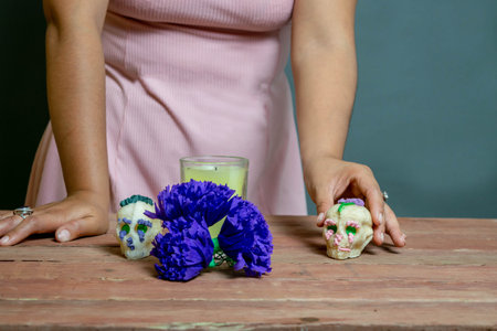 woman making Day of the Dead offering with sugar skull, flowers and candle. catrinaの写真素材