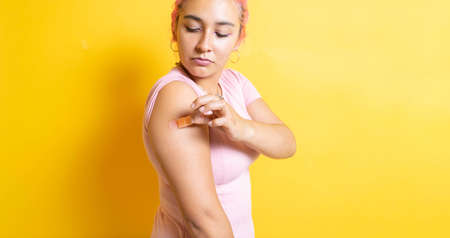 Mexican woman removing injection band, after being immunized against covid-19. hispanicの写真素材