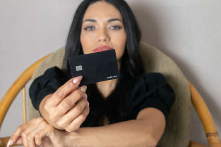 Hispanic woman showing credit card. finance and technology conceptの写真素材