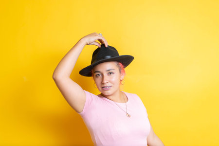 beautiful hispanic young woman with braces wearing fedora hat. mexican latinaの写真素材