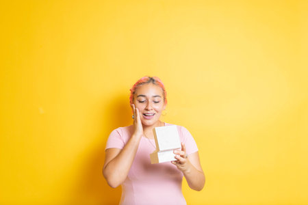 young mexican woman opening gift box with surprised face