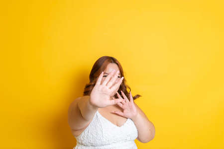 fashion portrait of sexy young chubby woman covering her distressed face. hispanic womenの写真素材