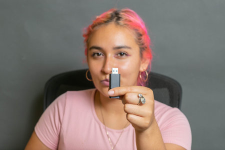 young hispanic woman showing usb stick