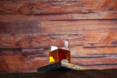 low view of whiskey or cognac glass on planksの写真素材