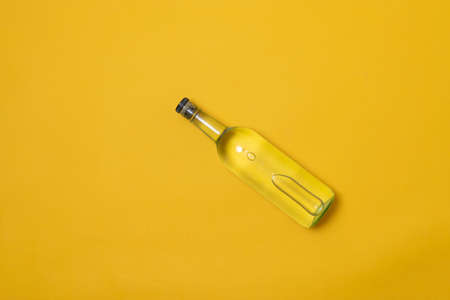 top view of bottle of tequila, mezcal or vodka on yellow backgroundの写真素材