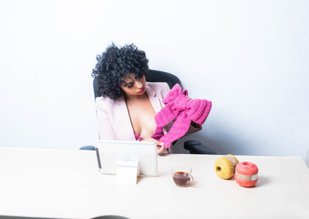 young latin mexican business woman showing yarn garment on video call