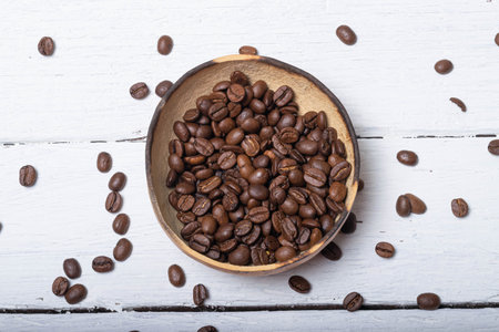 top view of organic coffee beans in artisan bowl on wooden planks