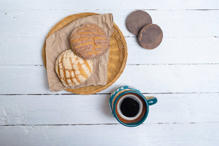top view of conchas sweet bread, chocolate bars and cup of mexican coffee