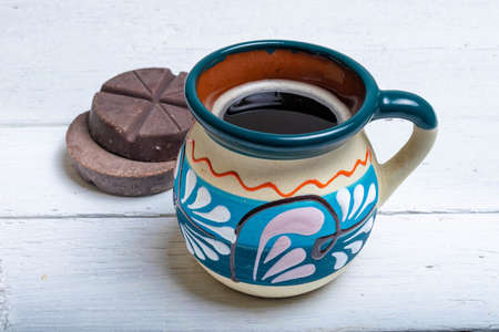 colorful cup of traditional Mexican coffee, in front of chocolate barsの写真素材