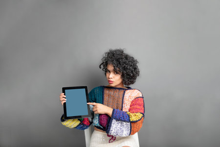 beautiful latin young woman wearing casual clothes showing tablet screen