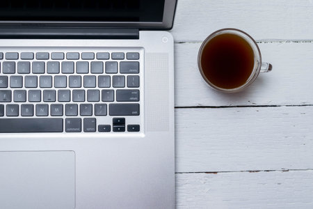 top view of laptop and cup of coffee on rustic wooden desk