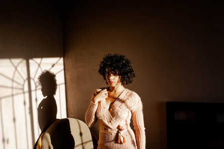 portrait of beautiful young latin woman in her bedroom at sunset