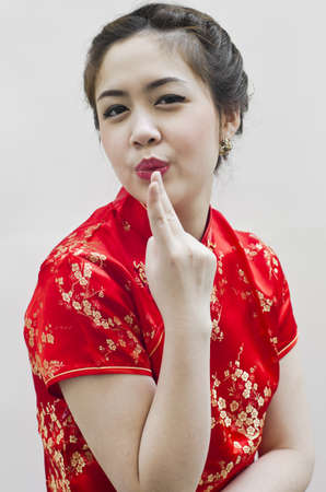 smiling beautiful chinese young woman gesturing with tradition clothingの写真素材
