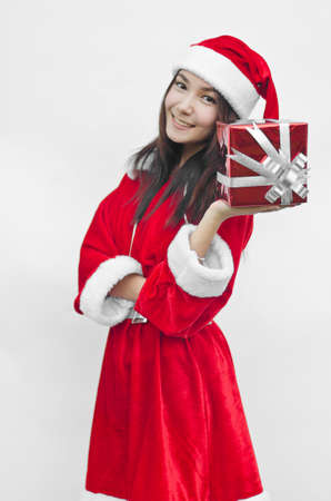 Portrait of young beautiful woman in santa claus hat with red christmas gift box with grey ribbons.の写真素材