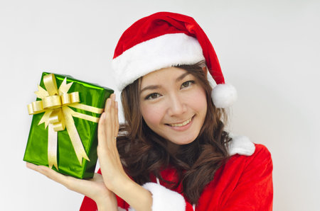 Portrait of young beautiful woman in santa claus hat with green christmas gift box with golden...