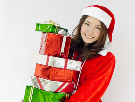 Portrait of young beautiful woman in santa claus hat with christmas gift boxes with ribbons.