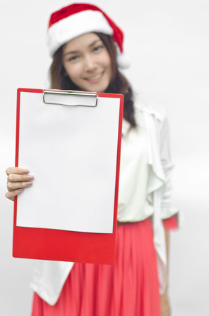 Girl in Santa hat holding banner. Cute funny photo closeup of christmas woman with copyspace....