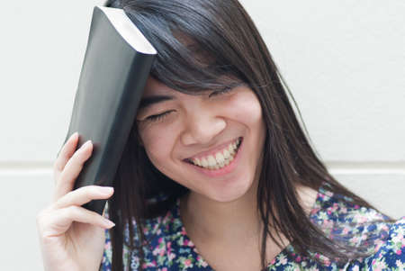 Teenage Asian girl reading a bookの写真素材