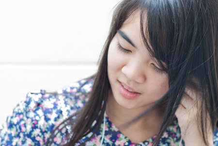 Young girl holding mp3 player in earphones on top of her head and listening musicの写真素材