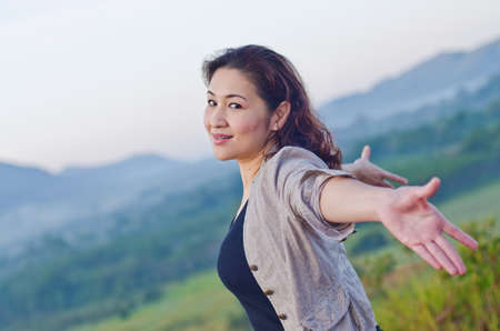 Pretty woman with opened arms expressing freedomの写真素材