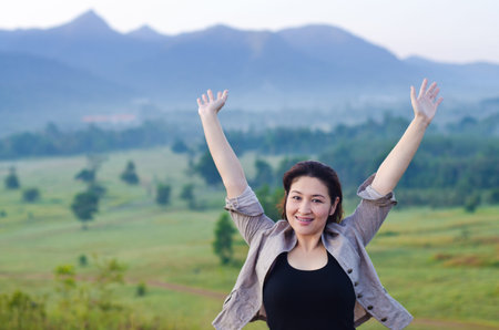 Pretty woman with opened arms expressing freedomの写真素材