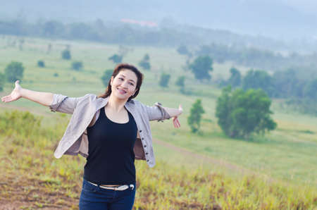 Pretty woman with opened arms expressing freedomの写真素材