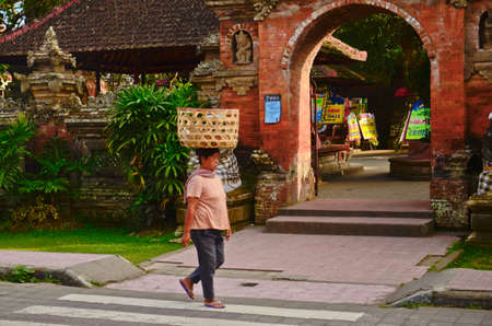 BALI - OCT 17: Unknown Indonesian women carry things in baskets on their heads in a procession on the streeet on October 17, 2013 in Ubud, Bali Indonesia.のeditorial素材