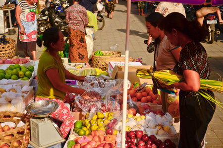 UBUD, BALI - OCT 17: Balinese woman in market sell fruits at the local market on October 17, 2013 in Ubud, Bali, Indonesiaのeditorial素材