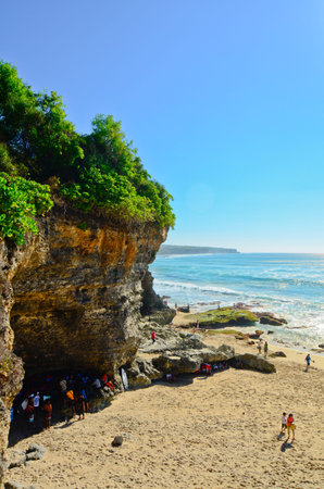 BALI, INDONESIA - OCT 18: Wide sand beach with tourists in sunny day on October 18, 2010. Dreamland beach, Bali, Indonesia. The Dreamland is one of the most popular surfing areas of Bali.のeditorial素材
