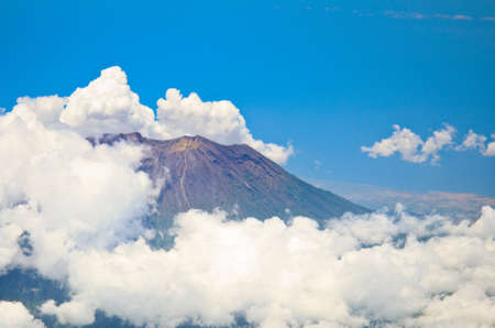 Aerial view of volcano Gunung Agung in Bali. Low clouds surrounds itの写真素材